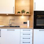 Moderne Küche mit Holzoberfläche, Spüle und integriertem Ofen.