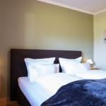Schlafzimmer mit Doppelbett, Nachttischen und Wandbild.