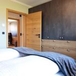 Schlafzimmer mit Bett, Kleiderschrank und Tür zum Arbeitszimmer.