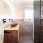 Bad mit Holzwaschtisch, Dusche und Fenster