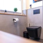 Sanitärzimmer mit Toilette, Pflanzen und Fenster