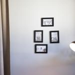 Wand mit vier schwarz-weißen Bildern und einer Lampe.