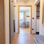 Flur mit Blick in Schlafzimmer und Essbereich mit Holzboden und Spiegel