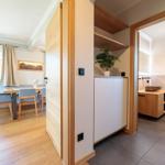 Eingangsbereich mit Blick in Wohn- und Badezimmer. Holzboden und moderne Einrichtung.