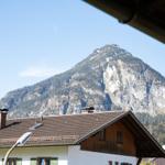 Von der Terrasse bietet sich ein Blick auf einen Berg mit Felsen und Wald.