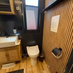 Bathroom with toilet, sink, and window with blinds.