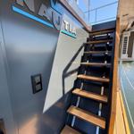 Staircase to deck with NAUTIA logo on wall