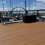 Deck with view of harbor and sailboats under blue sky.