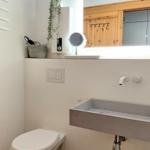 Badezimmer mit Toilette, Waschbecken und Spiegel