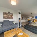 Wohn- und Essbereich mit Sofa, Kamin und Fernseher.