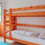 Zimmer mit Holz-Kojenbett, Fenster und Heizkörper