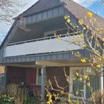 Modern villa with balcony and terrace in the garden. View of the roof and windows.