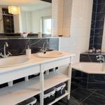 Doppelwaschbecken mit Spiegel und Badewanne in schwarz-weißem Marmor