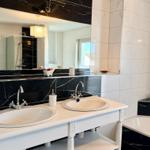 Badezimmer mit zwei Waschbecken, Spiegel und Dusche.