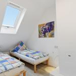 Room with two beds, skylight, and wall art.