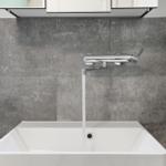 Bathroom with sink, faucet, and gray wall tiles