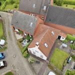 House with garden, terrace and multiple parking spots viewed from above.