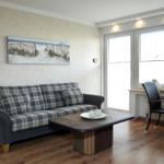 Wohnzimmer mit Sofa, Couchtisch und Fenster. Wandbild und Stehlampe sind sichtbar.