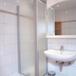Badezimmer mit Duschkabine, Waschbecken und Spiegel