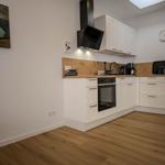 Kitchen with white cabinets, wooden countertop, and built-in oven.