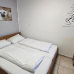 Schlafzimmer mit Doppelbett, Holzmöbel und Wanddekoration.