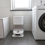 Badezimmer mit Saugroboter und Waschmaschine