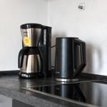 Küchenzeile mit Kaffeemaschine und Wasserkocher auf Arbeitsplatte