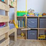 Kinderzimmer mit Holzbett und Spielzeugregal