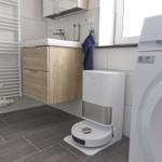 Badezimmer mit Waschmaschine, Handtuch und Spiegelschrank.