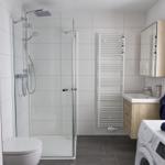 Bad mit Dusche, Waschbecken und Wärmewasserspender
