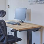 Arbeitsplatz mit Schreibtisch, Monitor, Tastatur und ergonomischer Sitzgelegenheit.