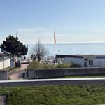 Blick auf Strand mit Strandkörben und Meer. Gebäude mit Schild Strand Olandt.