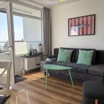 Wohnzimmer mit Sofa, Tisch und Aussicht aufs Meer.