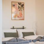 Schlafzimmer mit Bett, Kissen und Wandbild