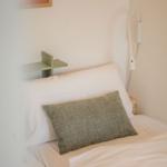 Bettkopfteil mit Kissen, Wandlampe und Bild an der Wand