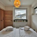 Zimmer mit zwei Betten, Fensterblick auf Haus und Hängelampe
