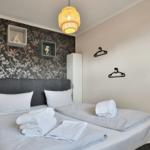 Schlafzimmer mit Doppelbett, dekorativer Wandtapete und Lampe.
