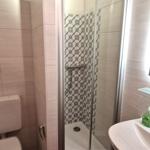 Badezimmer mit Dusche, Toilette und Waschbecken.