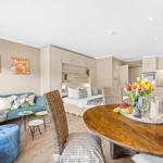 A room with sleeping area, living space, and dining table with chairs.