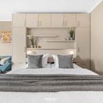 Bedroom with bed, nightstands, and integrated wardrobe. Blue sofa and wall art are visible.