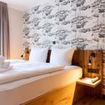 Schlafzimmer mit Bett, Holzkopfteil und Boots壁纸.