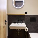 Badezimmer mit Waschbecken, Spiegel und Toilette
