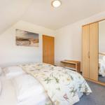 Schlafzimmer mit Doppelbett, Kleiderschrank und Wandbild