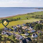 Haus in grüner Landschaft mit Blick auf einen See