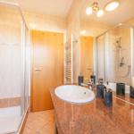 Badezimmer mit Dusche, Waschbecken und Spiegel