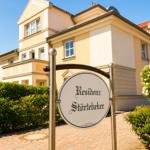 Residenz Störtebeker mit gepflegtem Garten und Schild an Eingang.