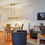 Wohn- und Essbereich mit Sofa, Tisch und Stühlen sowie Küchenbereich.
