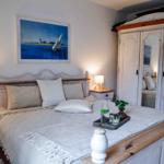 Schlafzimmer mit Bett, Nachttisch, Schrank und Wandbild.