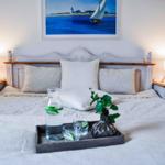 Doppelbett mit Kissen, Nachttischen und Bild an der Wand.