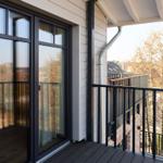 Terrasse mit Glas-Tür und Blick auf Bäume und Gebäude